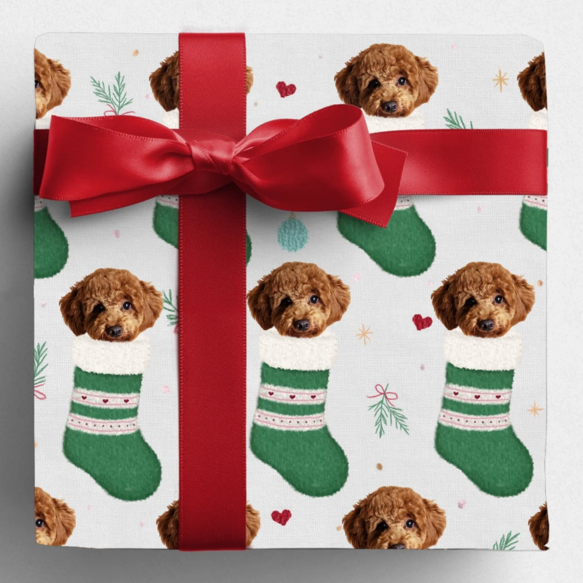 Gift wrapped in Santa's Stocking Stuffers paper with a red bow, featuring a curly-haired dog in green stockings