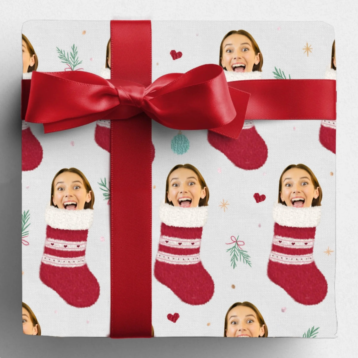 Gift wrapped in Santa's Stocking Stuffers paper with a red bow, featuring a woman's face in red stockings