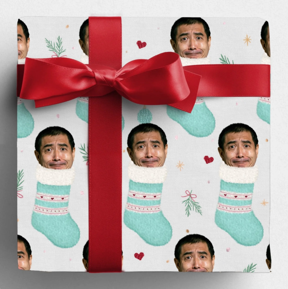 Gift wrapped in Santa's Stocking Stuffers paper with a red bow, featuring a man's face in mint stockings